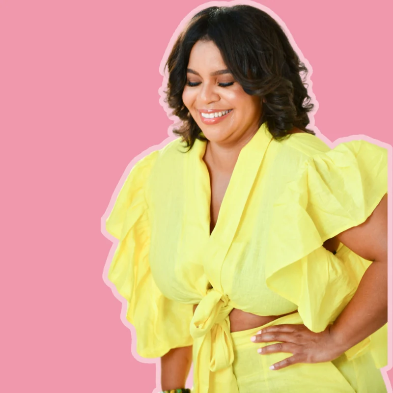 Karen M. Blackwell smiling in a yellow outfit against a pink background